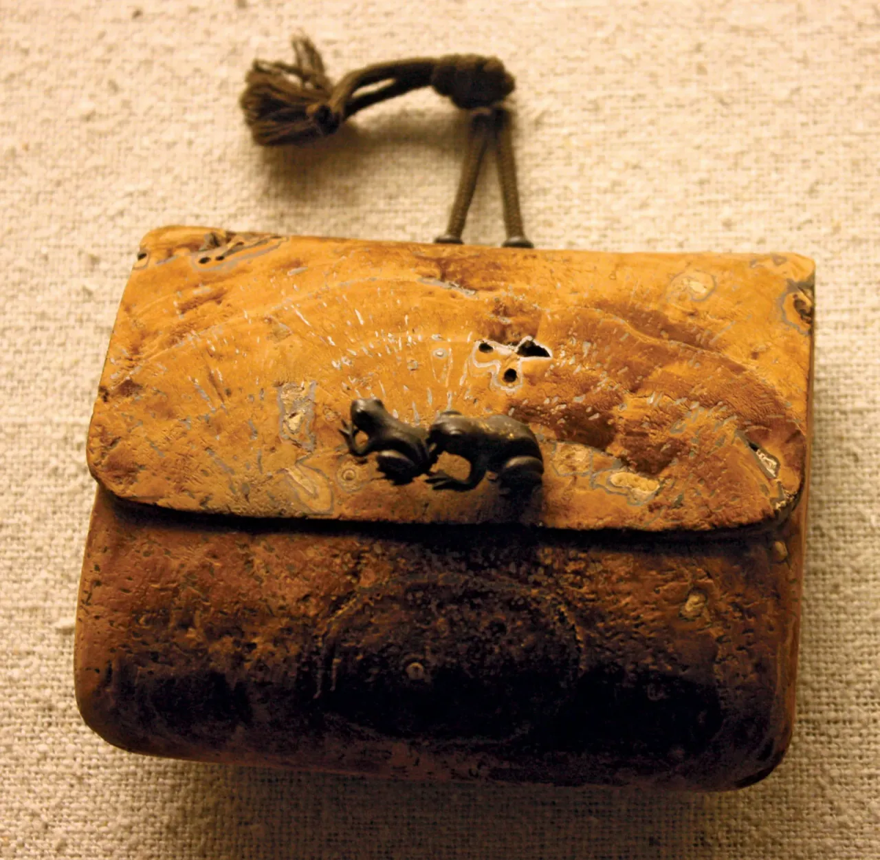 Tütün kesesi, kurutulmuş ve oyulmuş ağaç mantarı ve iki yaldızlı bronz kurbağalı ahşap kanat, Japonya, yak. 1800–50; Londra'daki Victoria ve Albert Müzesi'nde.
